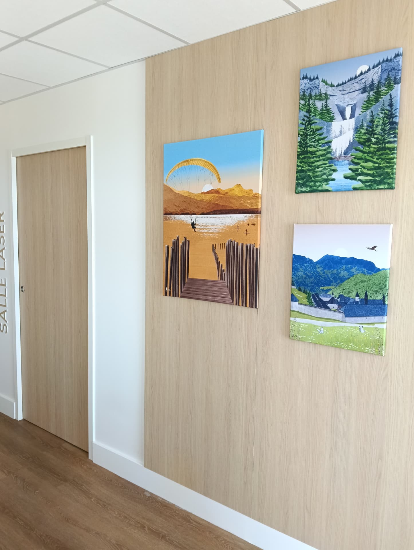 Fixation murale de trois toiles décoratives paysages sur cloison bois — aménagement de locaux professionnels à Chambéry