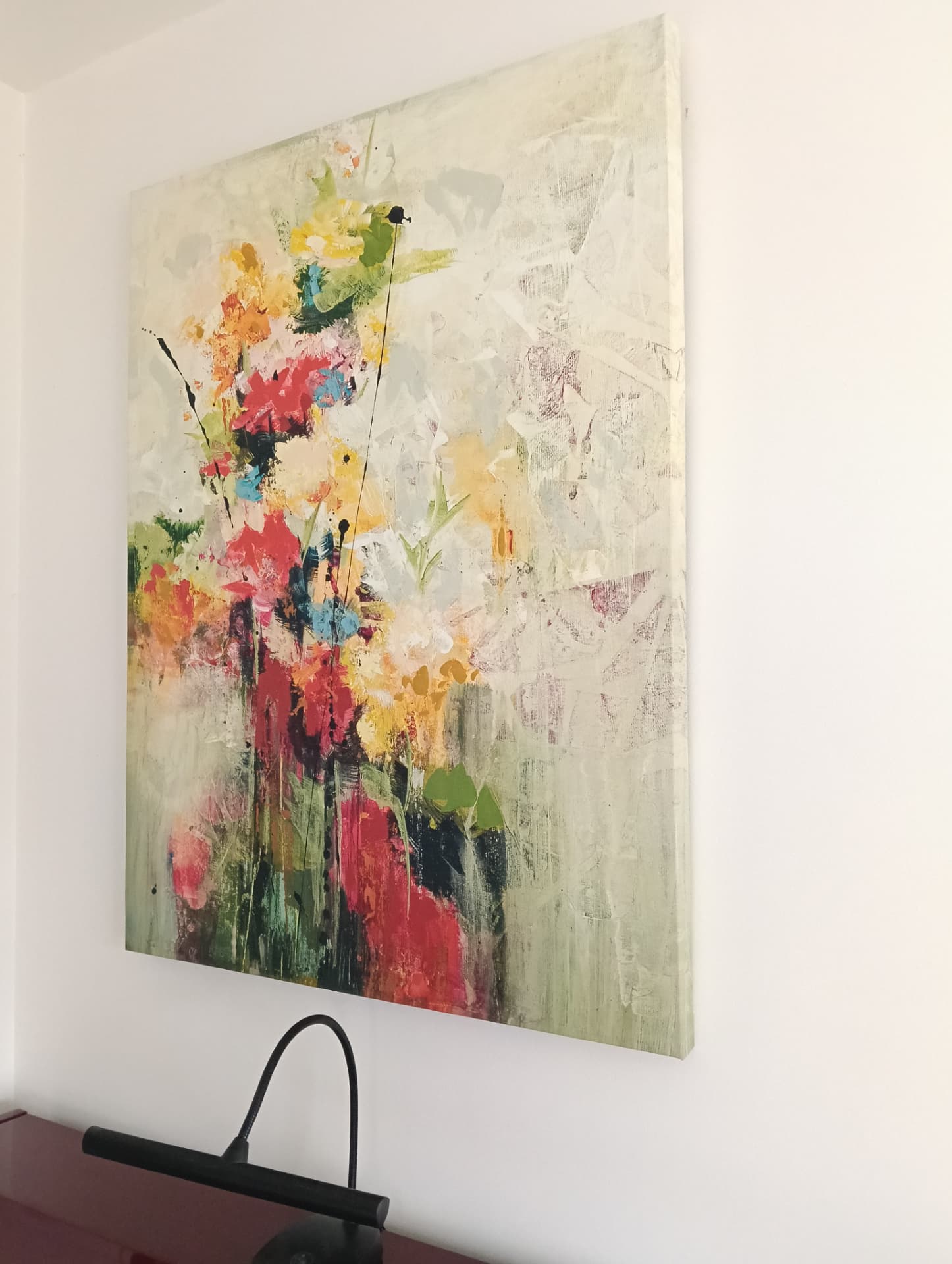 Fixation murale d'une grande toile florale abstraite colorée dans un salon à Aix-les-Bains