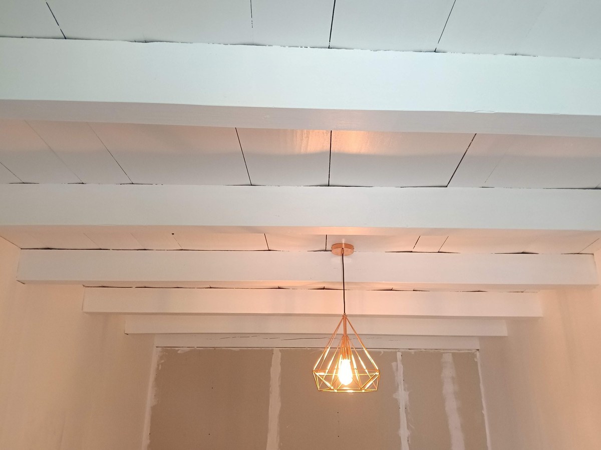 Plafond bois repeint en blanc à Hauteville-Lompnès — poutres apparentes éclaircies, rendu lumineux