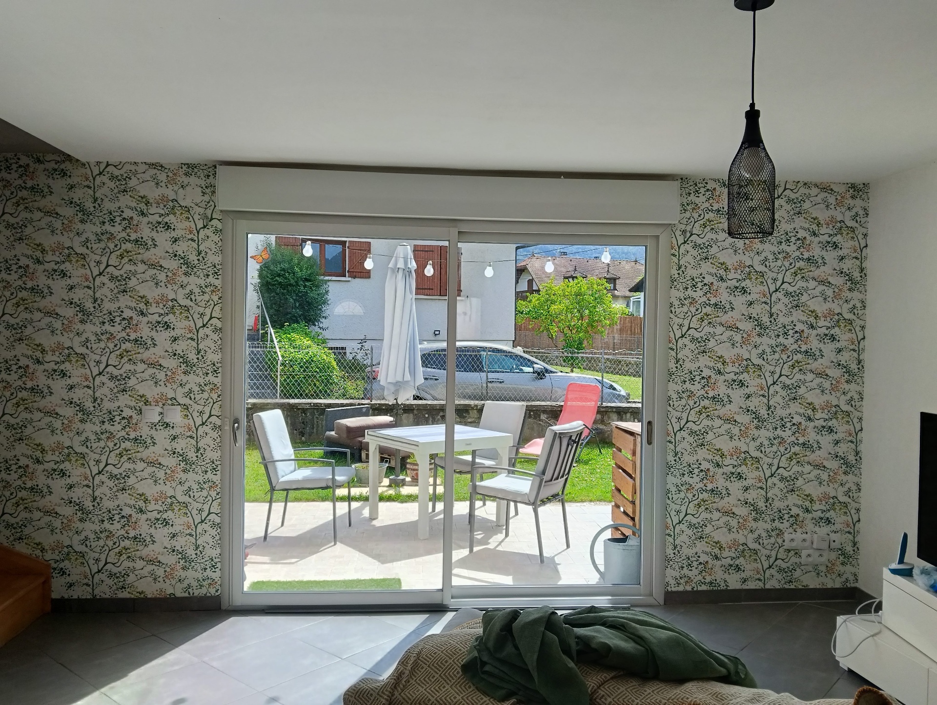 Décoration murale en papier peint motif arbres autour d'une baie vitrée — salon